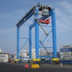 Épandeur électro-hydraulique à simple levage relié à un RTG à 16 roues.